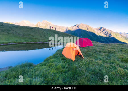 Silhouetten von Wanderern spiegeln sich im See mit Mont De La Saxe auf dem Hintergrund Courmayeur Aosta Tal Italien Europa Stockfoto