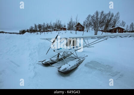Hydroplane auf dem eisigen Boden Frames die Holzhütten mit Schnee Ruka Kuusamo Österbotten Region Lappland Finnland Europa abgedeckt Stockfoto