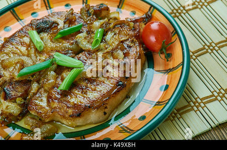 Glasierte Schweinekoteletts serviert Cherry Tomaten, hautnah. Selektiver Fokus Stockfoto