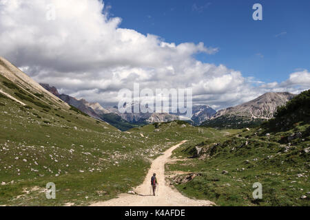 In Norditalien, in den Dolomiten. Eine Frau, die zu Fuß auf der langen Strecke route Alta Via 1 im Sommer, auf dem Weg zum Rifugio Sennes Stockfoto