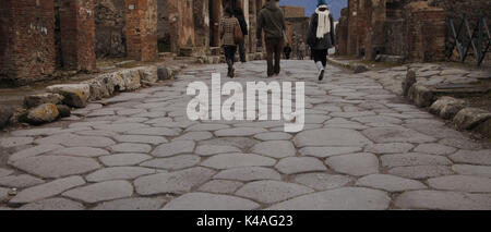 Italien. Pompeji. Touristen zu Fuß von der Straße mit Kopfsteinpflaster. Stockfoto