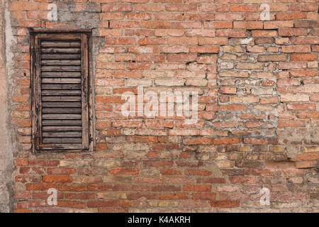 Alt und schäbig Ziegelmauer mit alten, alten Holz- Fenster Jalousien Stockfoto