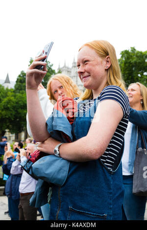 London, Großbritannien. Ein junges Mädchen lacht, während Sie Fotos Big Ben, wie es klingt seine endgültige Bongs für vier Jahre. Stockfoto