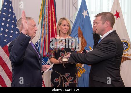 Us-Verteidigungsminister James Mattis, Links, verwaltet den Amtseid auf Ryan D. McCarthy für die 33 Unter Sekretär der Armee als seine Frau Jennifer McCarthy Blick auf während einer Zeremonie im Pentagon September 5, 2017 in Arlington, Virginia. Stockfoto