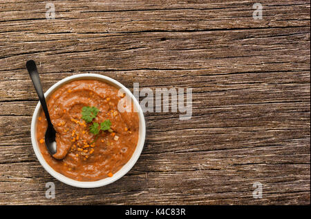 Rote Linsensuppe auf hölzernen Tisch Stockfoto