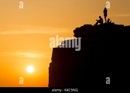 Drei Menschen genießen den Sonnenuntergang auf einer Klippe, Pulpit Rock Stockfoto