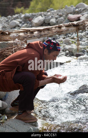Berber Mann trinken aus Fluss, setti Fatma Markt, ourika Tal, Marokko Stockfoto
