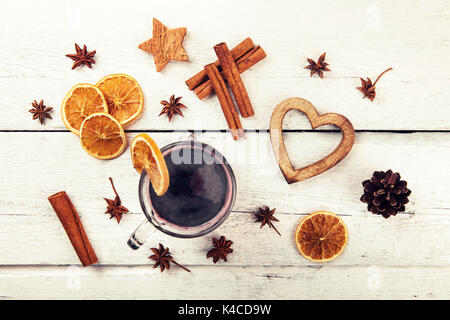 Glühwein mit Gewürzen und Dekorationen auf weiße Holztisch. top View Stockfoto