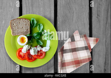 Frühstücksteller, Tomaten, Käse, Brot, Eier auf hölzernen Tisch Stockfoto