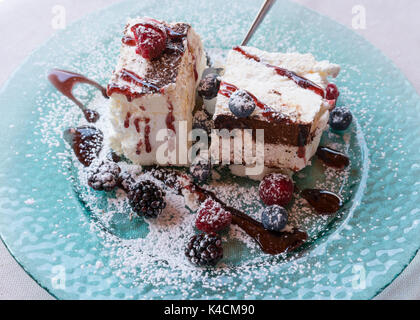 Süße baiser Kuchen (Pavlova) mit frischen Winter berry Früchte auf Glasplatte. Stockfoto