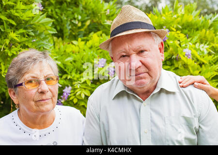 Behinderte senior Paar Hände des Betreuers im Garten outdoor Stockfoto