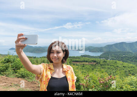 Weibliche Reisende selfie mit Ihrem Smart Phone und schöne Landschaft bei kanchanaburi Thailand Stockfoto