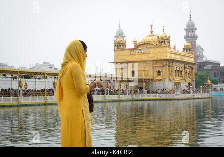 Amritsar, Indien - May 25, 2015. Eine Frau an der Goldene Tempel in Amritsar, Indien zu beten. Der Tempel ist der heiligste Gurdwara des Sikhismus, im 19. Stockfoto