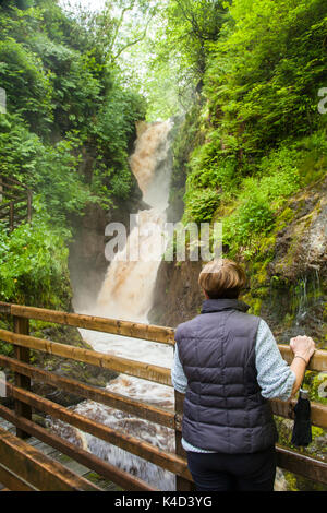 Frau an einem Wasserfall in Glenarif, Co Antrim, Nordirland Stockfoto