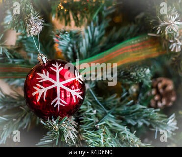 Weihnachten Band und rote Christbaumkugel mit gezogenen Schneeflocke auf Tanne Weihnachtsbaum Hintergrund Stockfoto