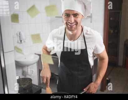 Vordere Portrait von glücklichen männlichen Koch in der Küche kochen Stockfoto