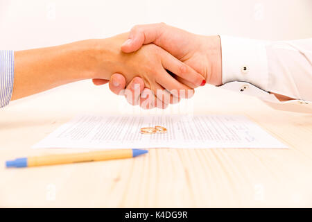 Nahaufnahme der ein junger Mann und eine junge Frau die Hände schütteln Nach der Unterzeichnung eine prenuptial Vereinbarung Stockfoto