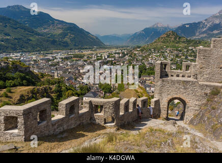 SION, SCHWEIZ - Stadtmauer von Tourbillon Schloss, Vordergrund, und Ansicht von Sion, im Kanton Wallis. Stockfoto