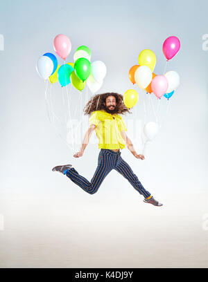 Konzeptionelle Porträt einer kindlichen Kerl springen mit Ballons Stockfoto