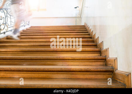 Motion Blur, Mann geht nach oben, alte hölzerne Treppe Stockfoto