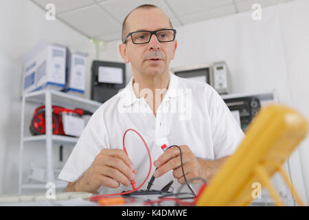 Ältere Menschen die Kalibrierung mit einem digitalen Multimeter Stockfoto