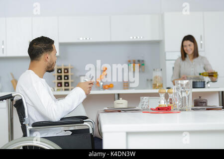 Behinderte im Rollstuhl zusammen - Mann paar kochen Stockfoto