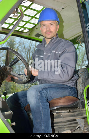 Mittleres Alter Mann im Traktor auf der Farm Stockfoto