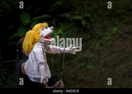 Puppenspiel - Schauspieler und Puppen in den intelligentesten Riese in der Stadt in das Open Air Amphitheater im Trebah Garten in Cornwall. Stockfoto