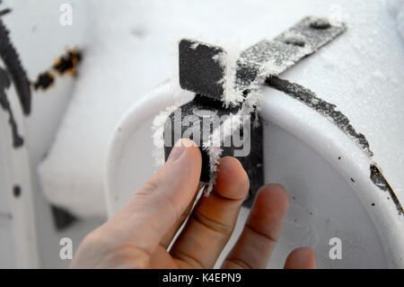 Ein Mann erste e-Mail aus einem Frost bedeckt Mailbox im Winter. Stockfoto