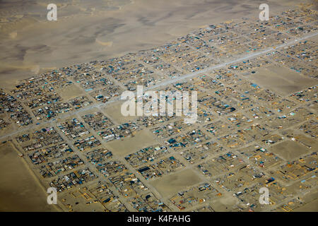 Dünen und Shanty Stadt am Stadtrand von Ica, Peru, Südamerika - Luft Stockfoto