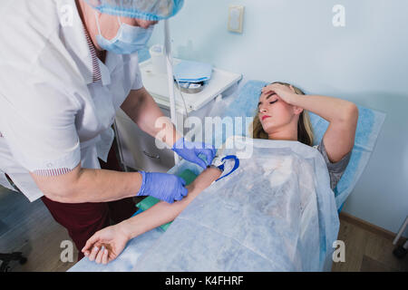 Professionelle Pflegekraft einer Frau liegt auf dem OP-Tisch am Klinikum Vorbereitung Narkose medizinische Arztpraxis Konzept eine Injektion zu Stockfoto