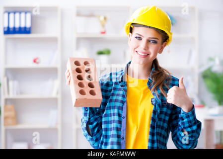 Frau mit Ziegel in der Bauwirtschaft Konzept Stockfoto