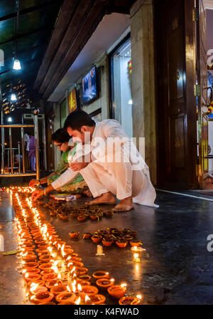 NEW DELHI, INDIEN - ca. Oktober 2016: Paar Beleuchtung Kerzen für die diwali Feier am Sai Baba Tempel in der Hauz Khas Bereich von New Delhi. D Stockfoto