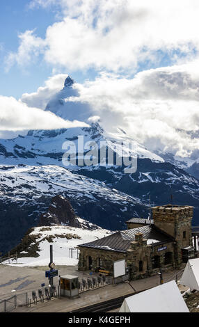 Majestic verträumter Blick auf verschneite Gornergrat Station und der legendäre Matterhorn Gipfel ummantelt mit Wolken, Zermatt, Schweiz, Europa. Stockfoto