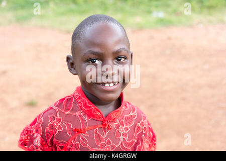 Eine schöne kleine Ugandischen schwarze Mädchen in roter Seide Bluse angezogen Stockfoto