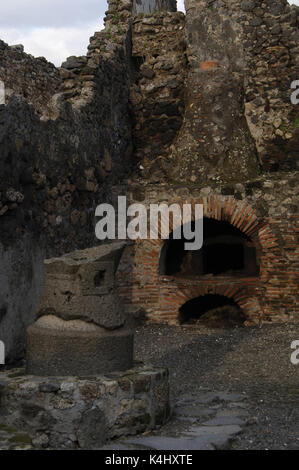 Italien. Pompeji. Pistrium. Backofen für Brot, alte Mühle von Korn und der Kamin des Ofens. Stockfoto