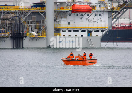 Caland Kanal, Rotterdam, Niederlande, 29. Mai 2014: Die Besatzung der Dockwise semi-submersible Schiff segeln in einem kleinen Arbeitsboot Stockfoto