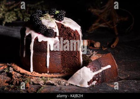 Unglaublicher Schokoladenkuchen. Dunkler und feuchter Schokoladen-Fudge-Kuchen. Kuchen mit Brombeeren und Zimt auf dunklem Hintergrund. Stockfoto