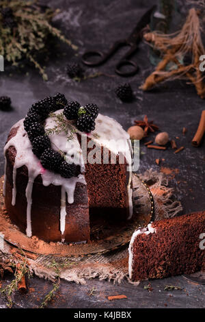 Unglaublicher Schokoladenkuchen. Dunkler und feuchter Schokoladen-Fudge-Kuchen. Kuchen mit Brombeeren und Zimt auf dunklem Hintergrund. Stockfoto