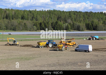 Salo, Finnland - 26. Mai 2017: Blick auf die Baustelle für die Installation von modernen landwirtschaftlichen Entwässerung auf einem Feld mit Ausrüstung und Handwerker in Aktion o Stockfoto