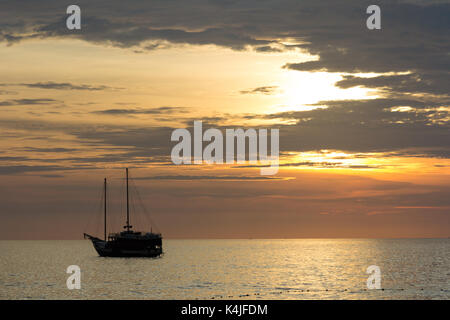 Yacht Silhouette bei Sonnenuntergang, Surin Beach, Phuket, Thailand Stockfoto