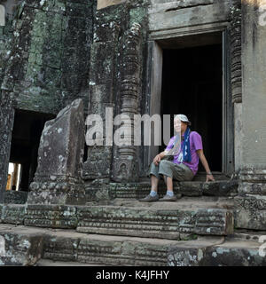 Älterer Mann an der Tür der Tempel sitzen, Siem Reap, Kambodscha Stockfoto