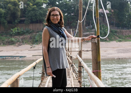 Frau stehend auf Bambus Brücke, Fluss Nam Khan, Luang Prabang, Laos Stockfoto