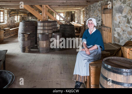 Frau in Kostümen sitzen auf Fässer in des Königs Lagerhaus auf der Festung von Minden, Minden, Cape Breton Island, Nova Scotia, Kanada Stockfoto