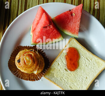 Westliches Frühstück mit Brot, Butter, Marmelade und Obst. Close Up. Stockfoto