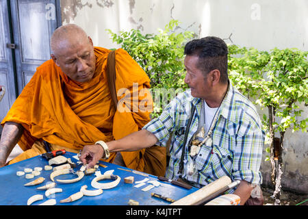 Thailändischen buddhistischen Mönch Amulette diskutieren mit einem Anbieter, Bangkok, Thailand Stockfoto