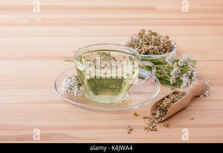 Tasse mit Schafgarbe Tee auf einem hölzernen Boden Stockfoto