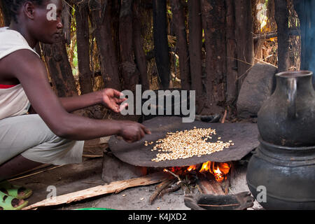 Eine Frau braten Kaffeebohnen auf offenem Feuer, Äthiopien, Afrika Stockfoto