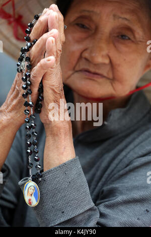 Alte vietnamesische Frau zu beten mit dem Gebet Perlen, St. Philip Kirche (huyen Sy Kirche), Ho Chi Minh City, Vietnam, Indochina, Südostasien, Asien Stockfoto