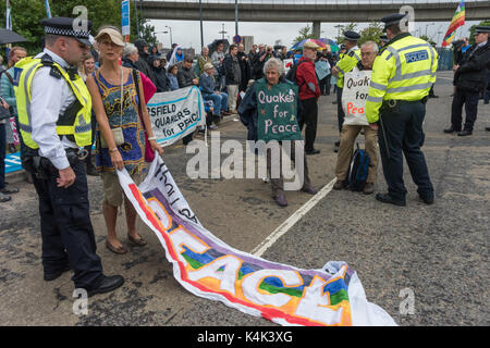 September 5, 2017 - London, UK - London, UK. 5. September 2017. Polizei sprechen Sie mit Quaker Demonstranten auf die Straße Am zweiten Tag der Proteste gegen die größten Waffen der Welt in den Londoner Docklands abgehalten. Die "Kein Vertrauen in Krieg" Tag war eine Reihe von Veranstaltungen, die von verschiedenen Glauben Gruppen organisiert. Bevor ich ankam hatte es einen Lock-in auf der Zufahrtsstraße stoppen Lieferungen auf der Messe über das Tor zu setzen. Dies wurde gefolgt von einem Quaker Meeting an der Seite der Straße, bei dem eine Reihe von Personen stand oder lag die Straße zu blockieren und mehrere, die sich weigerten, sich zu bewegen, wurden festgenommen. Stockfoto